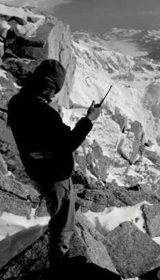 Climber standing on a ridge talking into a radio