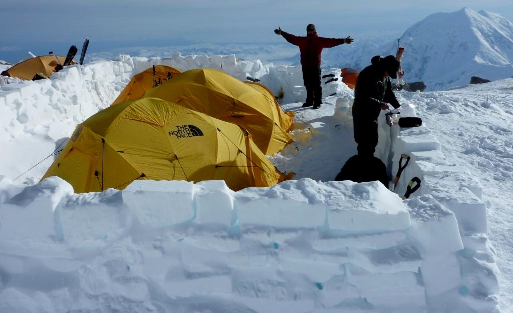 Tents and climbers enclosed by snow walls