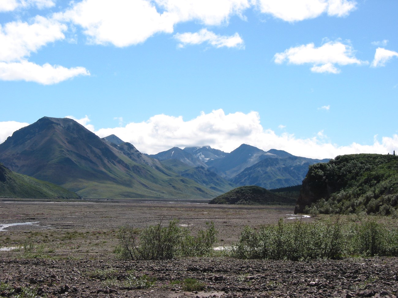 a flat, gravel-covered plain leading up to mountains
