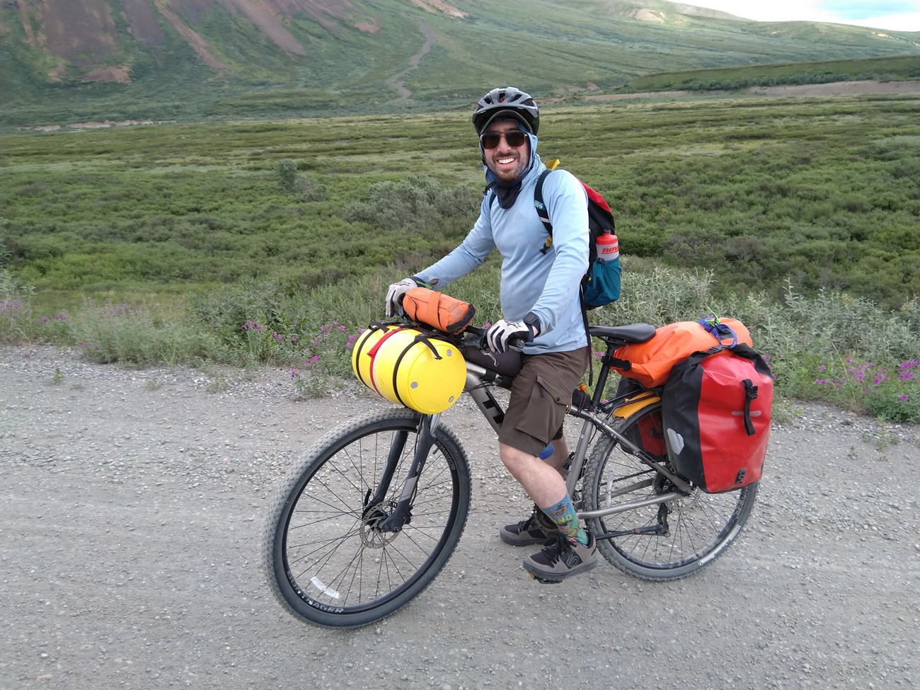 person biking with a large plastic canister attached to the bike