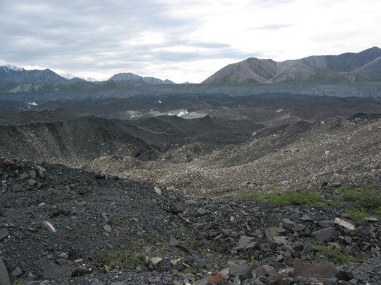 a rough, rocky landscape, with mountains in the distance