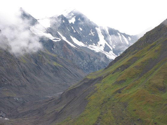 a narrow valley flanked by steep, rugged mountains