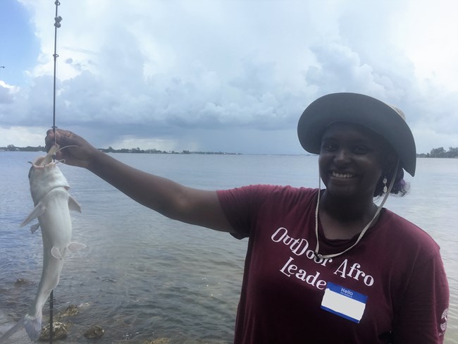 A Fishing Rancho Participant holding up a fish on a line