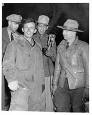 George Hopkins (left foreground) with park superintendent (right) and reporters (background)