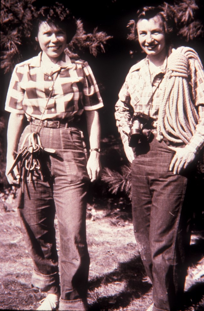 Two women standing with rock climbing equipment