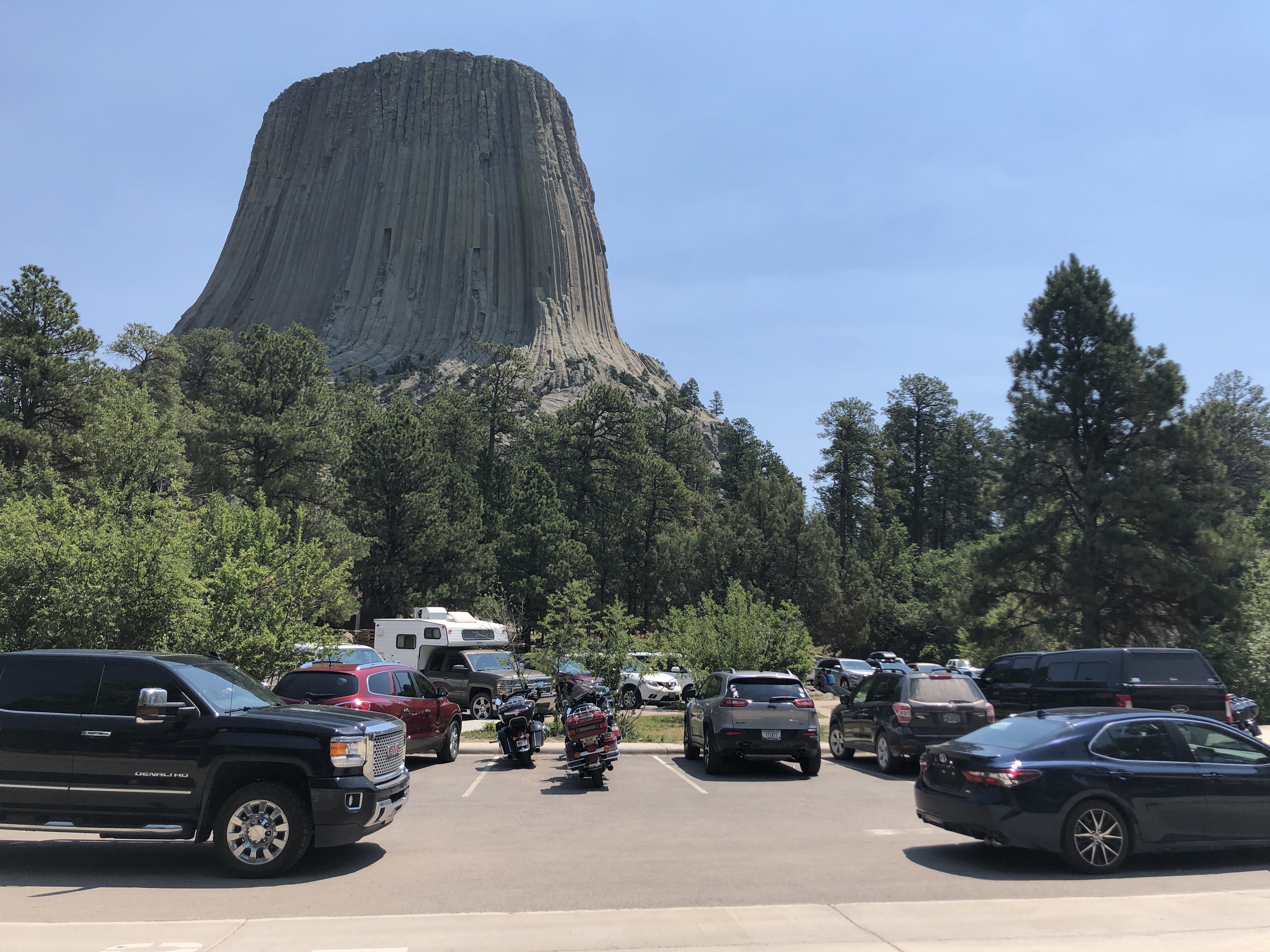 Vehicles in parking lot with Devils Tower in the background.