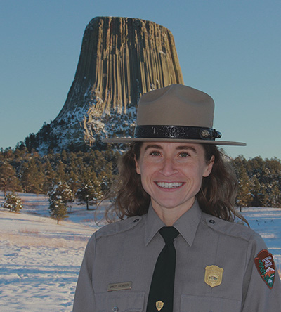 Park Ranger with hat on devils tower in background