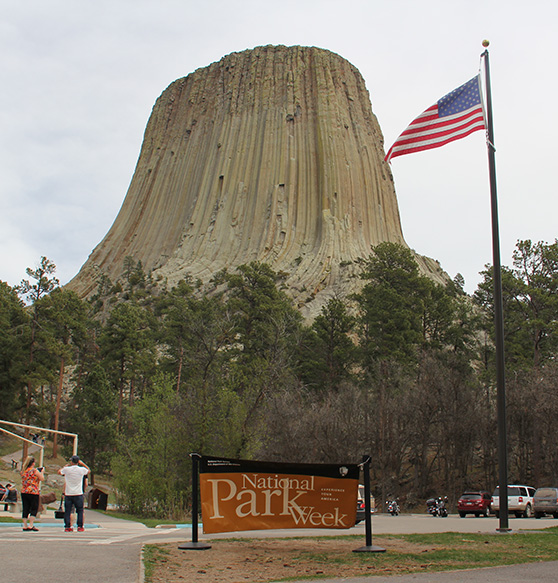 A parking area with a tall rock monolith beyond.