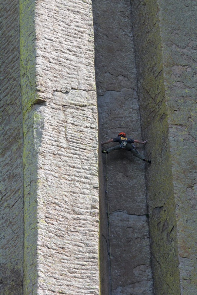 A climbing ranger stretches to complete a climb