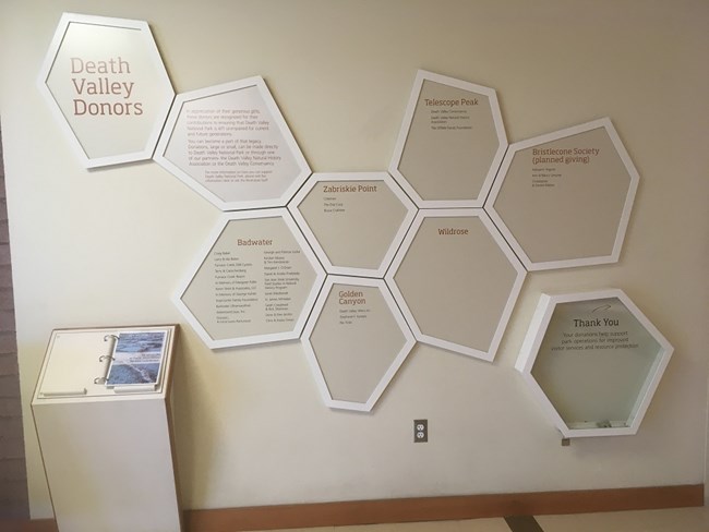 The donor recognition wall is adjacent to the information desk in Furnace Creek Visitor Center. It has polygons similar to the salt pan that recognize different donation levels. The donor recognition wall is adjacent to the information desk in Furnace Creek Visitor Center. It has polygons similar to the salt pan that recognize different donation levels.