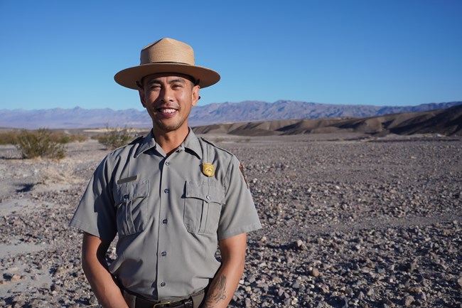 A park ranger stands in a desert landscape.