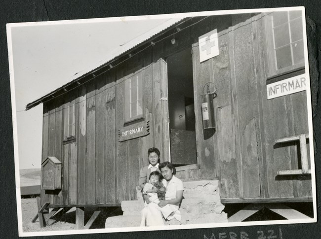 Women and children on the steps of a makeshift infirmary.