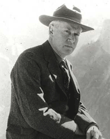 Historic photograph of Stephen Mather, seated and wearing a hat.