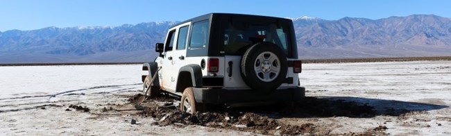 White jeep stuck in mud and salt flats.