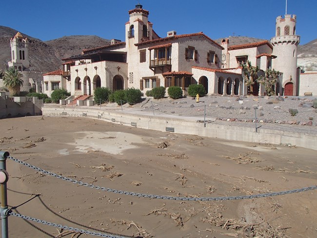 a pool by a castle, filled with brown water