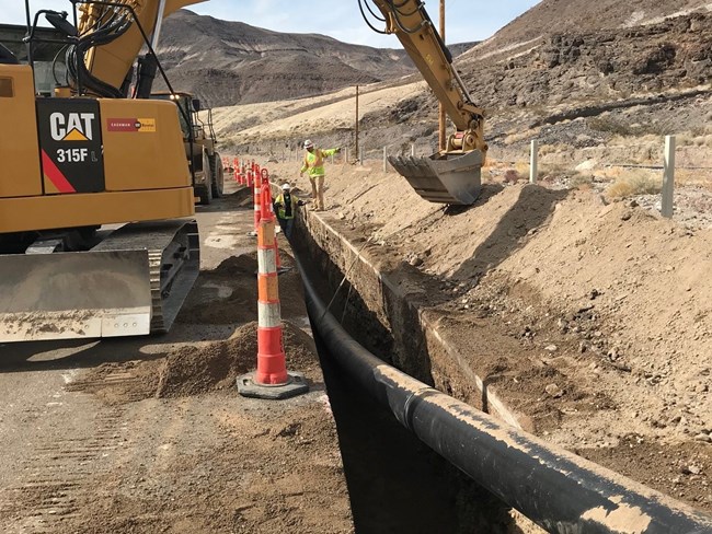 a pipe being placed in a trench