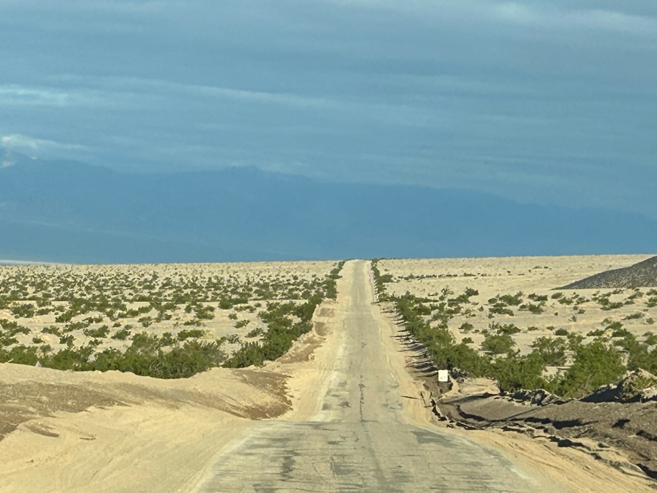 Desert road and speed limit sign with no dirt on the road.