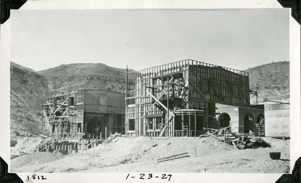 DEVA 40419 Black and white photograph of a two-story rectangular building under construction. It is surrounded by scaffolding and is missing the middle third of the building.
