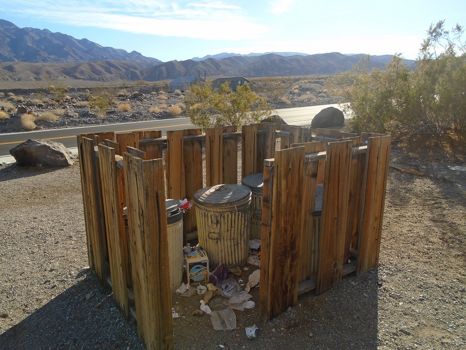 Trash is seen scattered around trash cans near Emigrant Restroom.