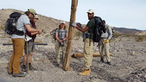 AmeriCorps crew picking up historic railroad ties washed out of their original location by a flash flood.