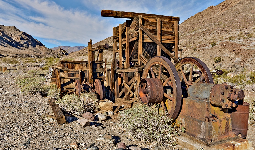A metal and wooden structure sits in a desert canyon.