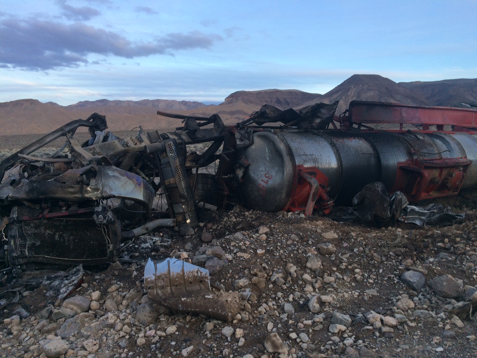 A semi-truck wrecked and crumpled in the foreground.