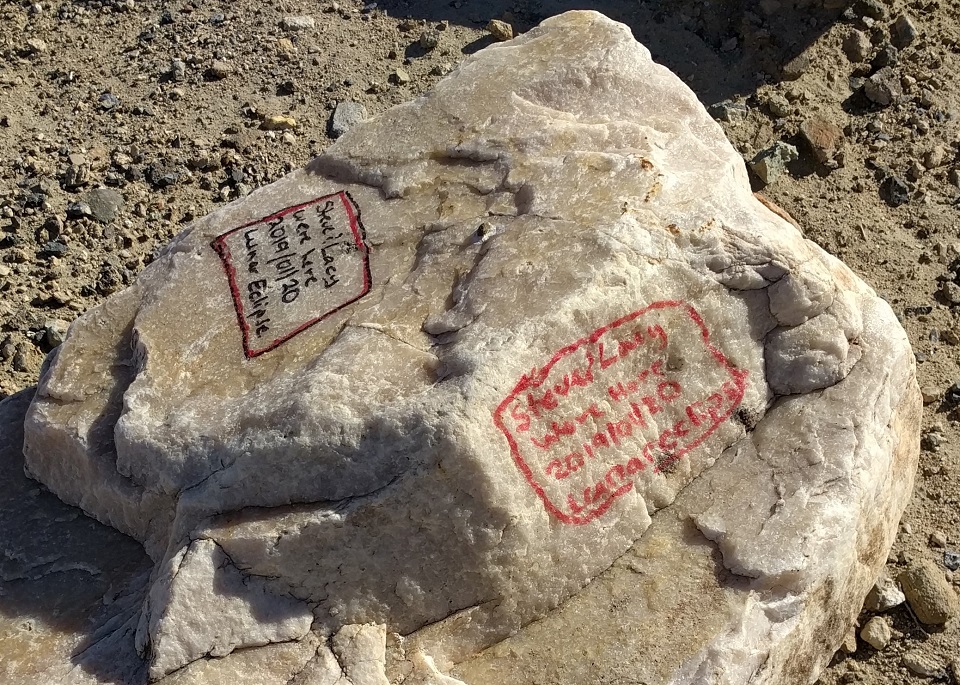 Graffiti on two sides of a light color boulder is from 2019 and 2020, marked "Steve & Lacy".