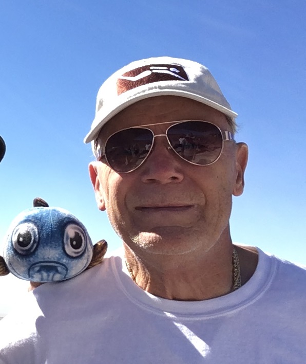 Photograph of volunteer Tom Jaskulski with a toy pupfish on his shoulder