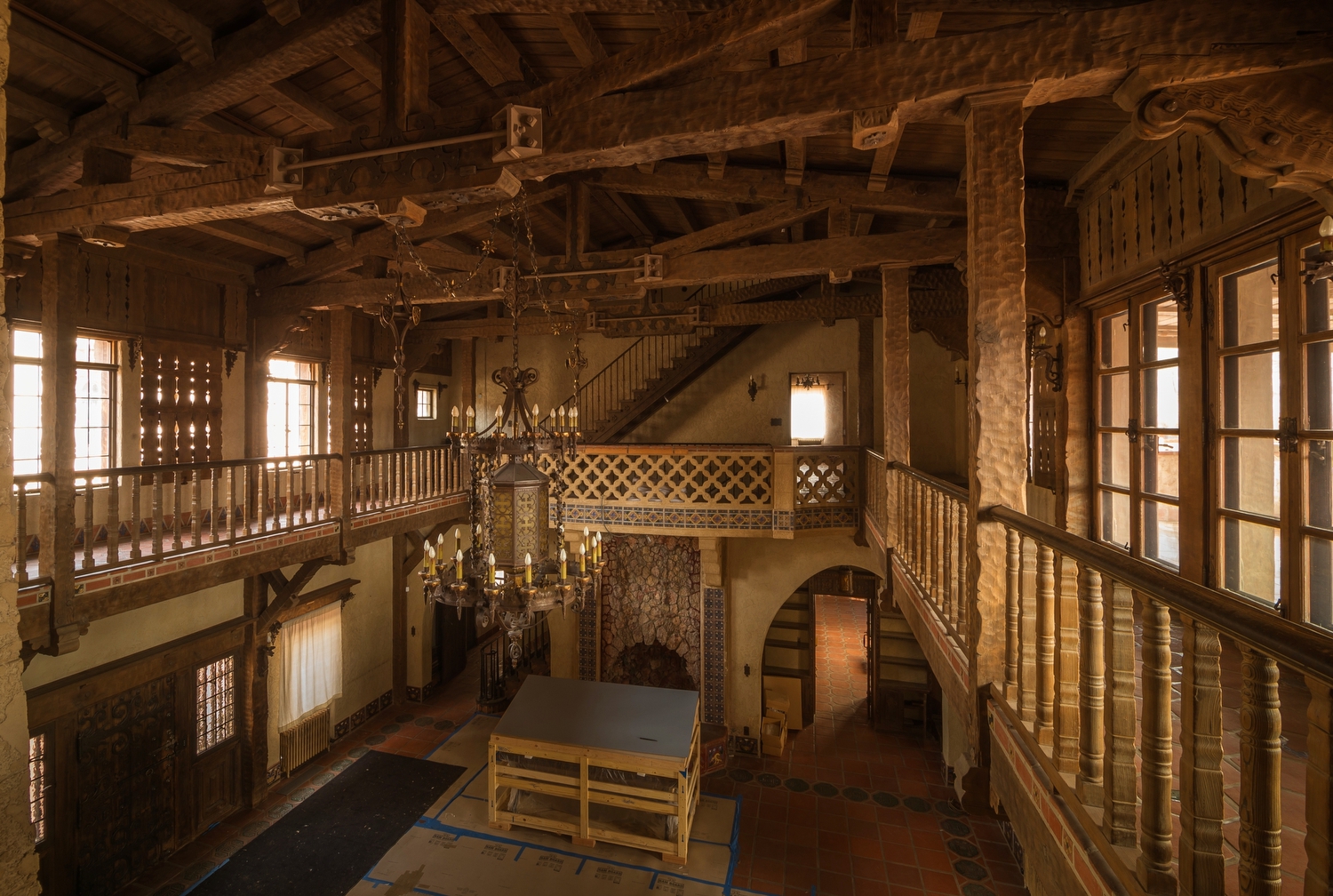 Ornate, wooden, two-story hall decorated with ornate furniture.