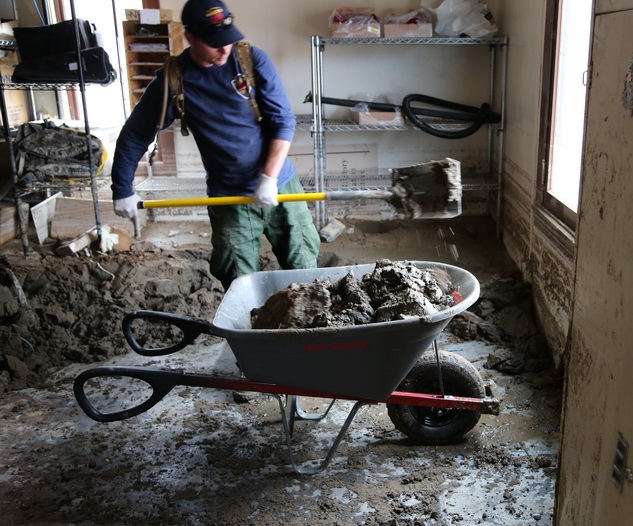 Shoveling mud inside Scotty's Castle Visitor Center