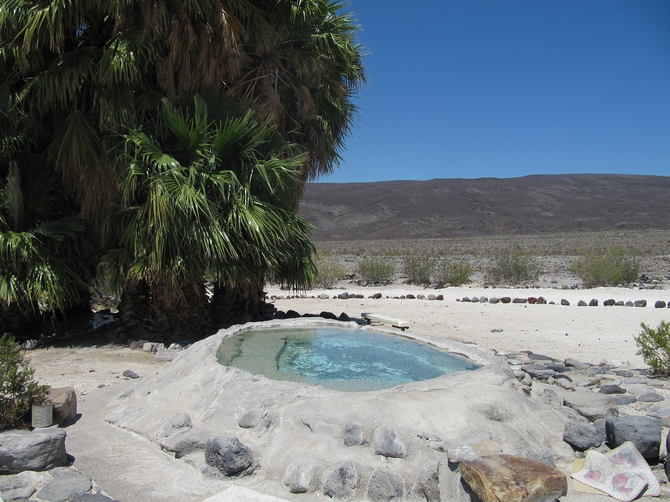 A small soaking pool is in the foreground with white edges mounded up on sides.