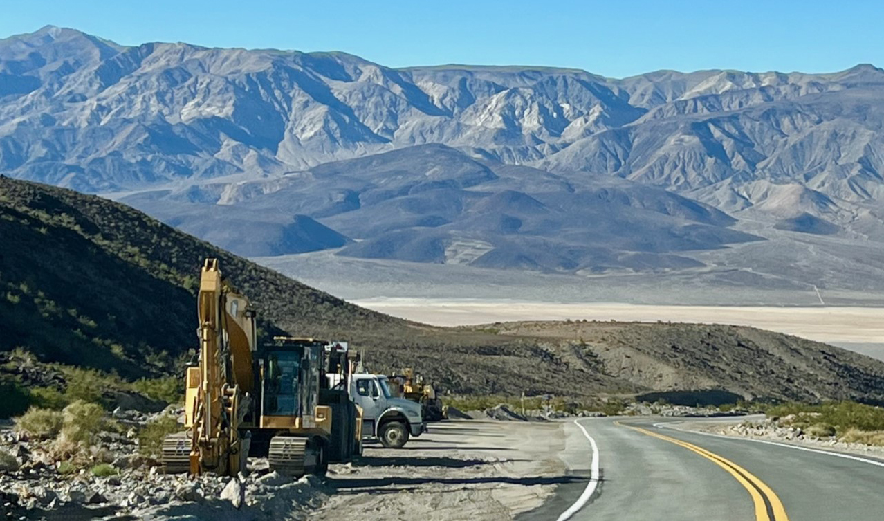 View of Towne Pass section of CA-190 overlooking Panamint Valley. Contruction vehicles stationed on shoulder of the paved road.
