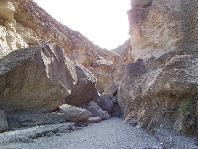 A pile of large boulders blocks passage inside a canyon.
