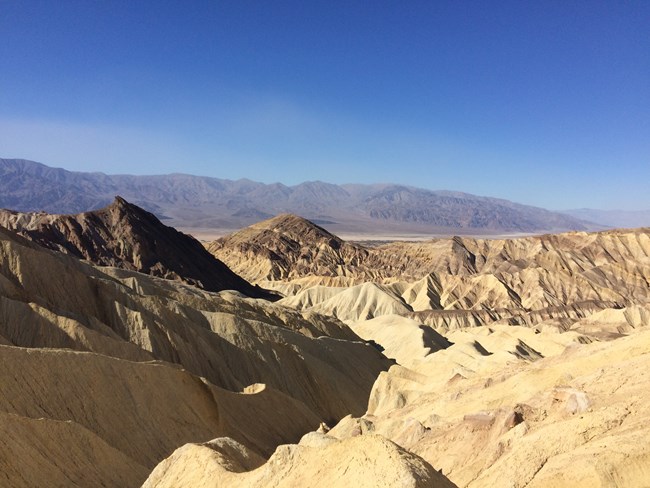 Golden colored hills and a labyrinth of canyons.