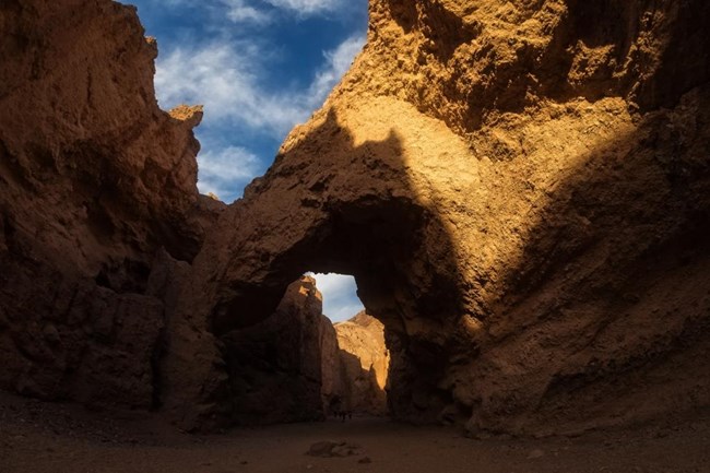 A natural bridge spans a desert canyon.