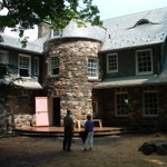 two people stand in front of stone house