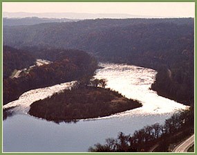 view into the sunlight of an island in a large river