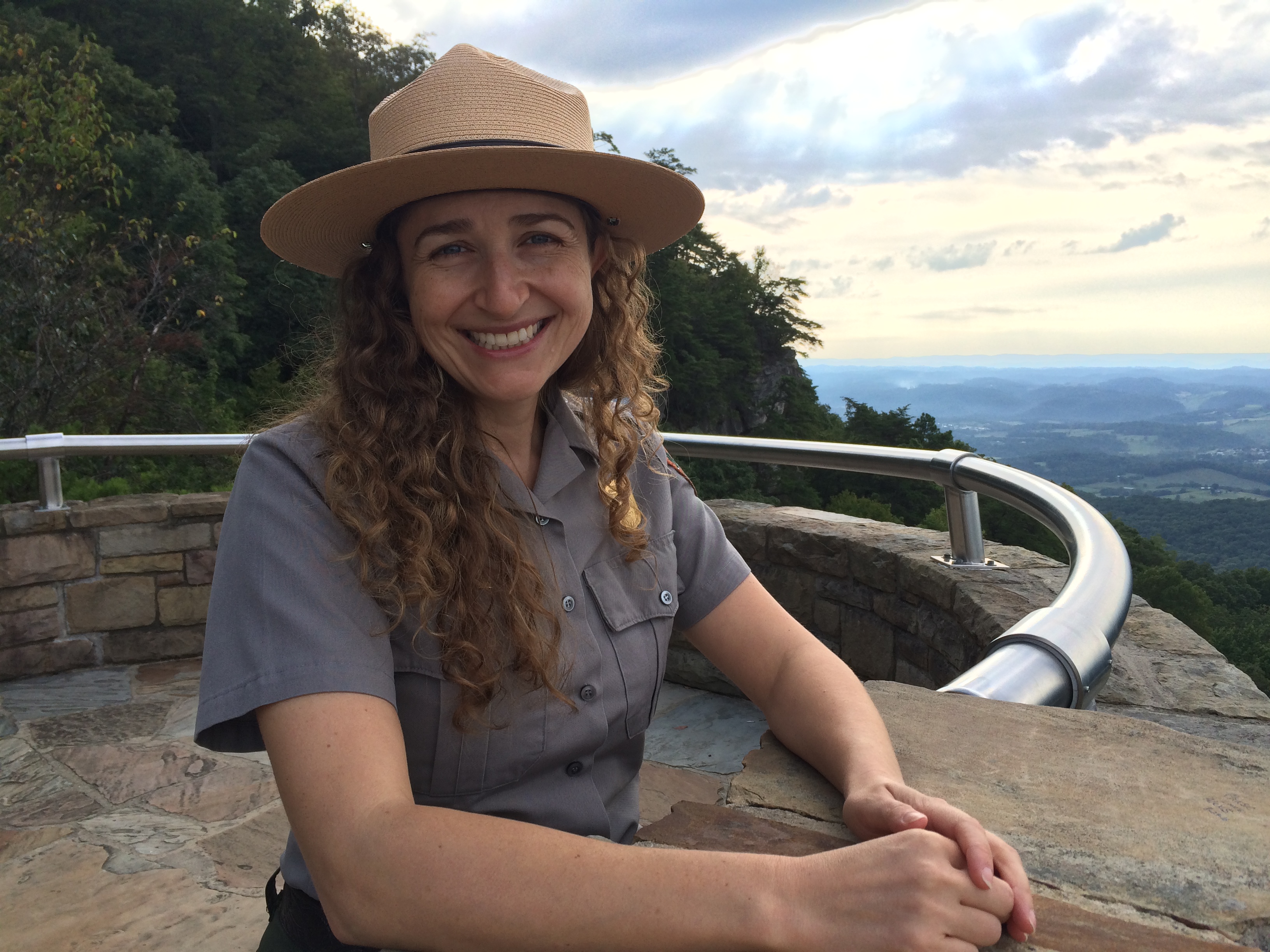 Park ranger in uniform standing on scenic overlook