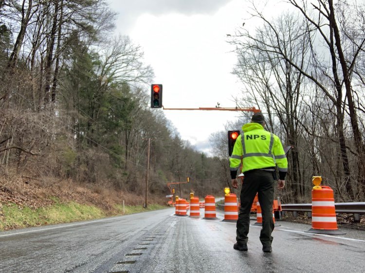 A park employee stands on Route 209 and checks the newly installed traffic lights.