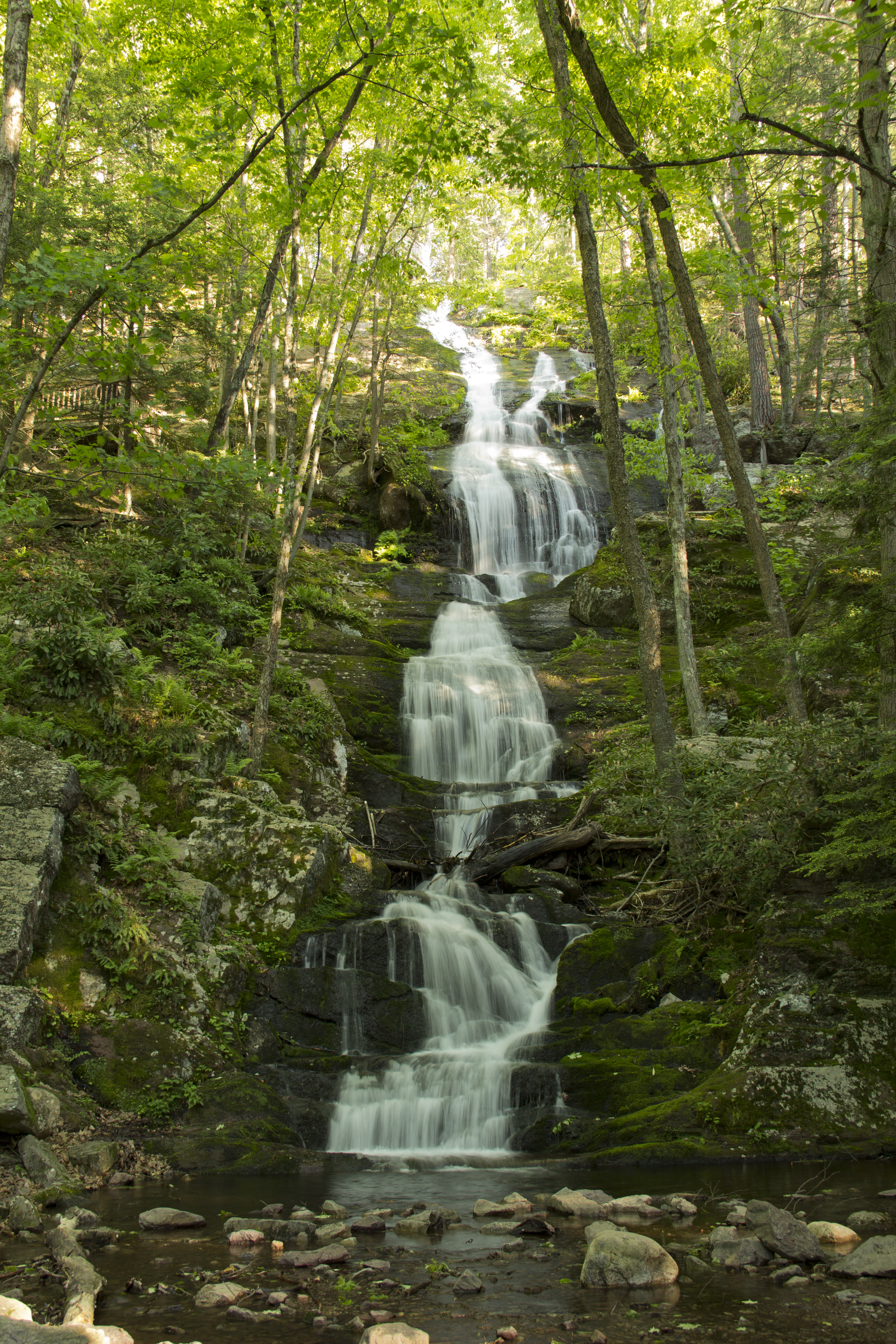 buttermilk falls A 75-foot cascade of water falls over rocky cliffs which are surrounded by green forests.
