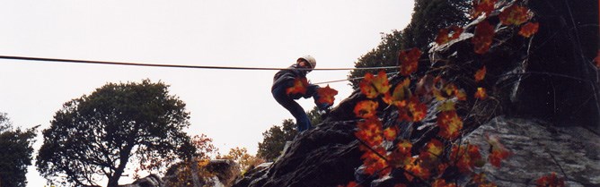 Climber on ropes descending a rocky cliff