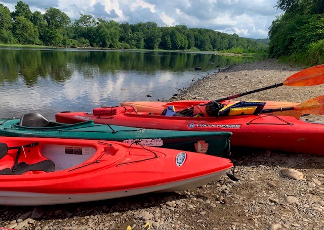 Kayaks on the shore of the Delaware River.