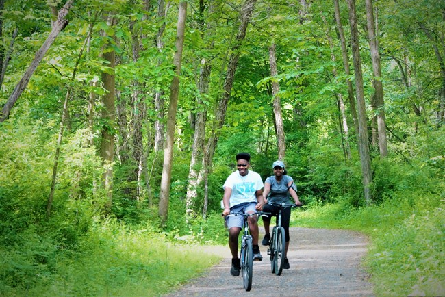 A young woman and man bike the McDade in summer