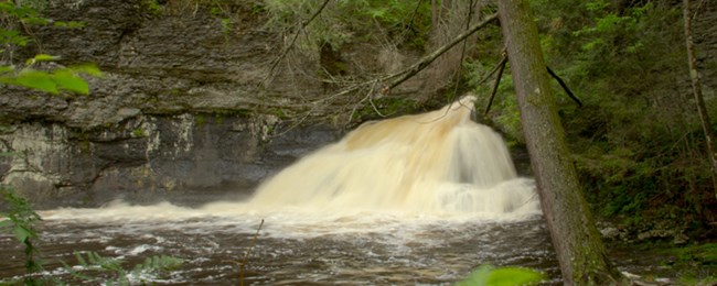 waterfall fanning over rocks into a pool of water