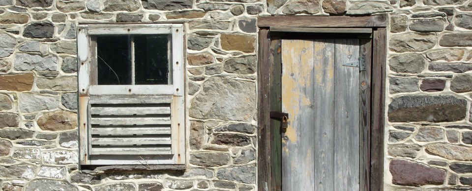 close up of old window and door on a stone building close up of old window and door on a stone building