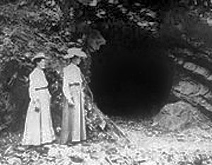 historic image of two ladies standing in front of a mine entrance historic image of two ladies standing in front of a mine entrance