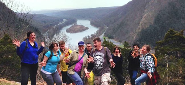 group of hikers in a silly pose on an overlook with the river in the background group of hikers in a silly pose on an overlook with the river in the background
