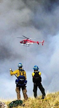 fire fighters with a helicopter above the horizon fire fighters with a helicopter above the horizon