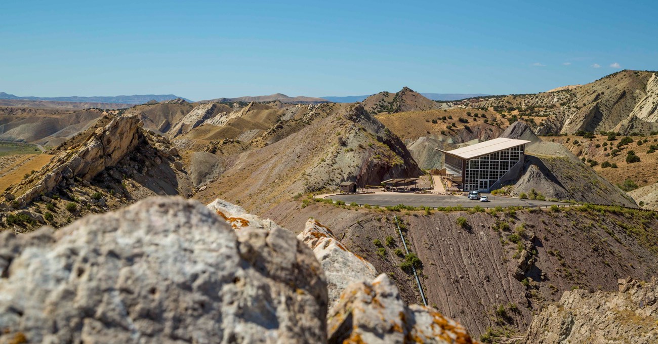 A distant view of the Quarry Exhibit Hall built into the side of the Morrison Rock Formation.