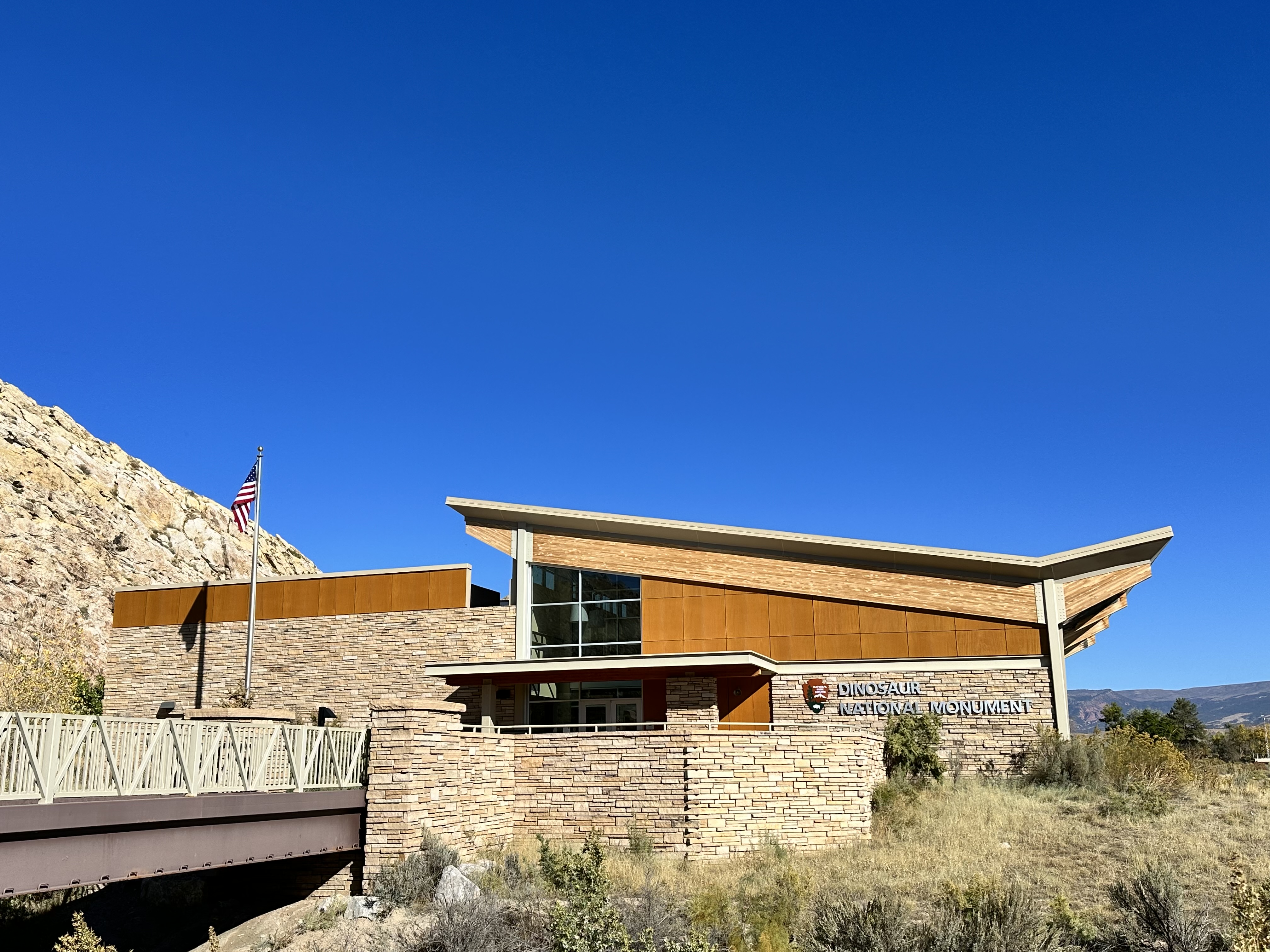 Quarry Visitor Center in fall Building with slanted roof and stone walls under a clear blue sky